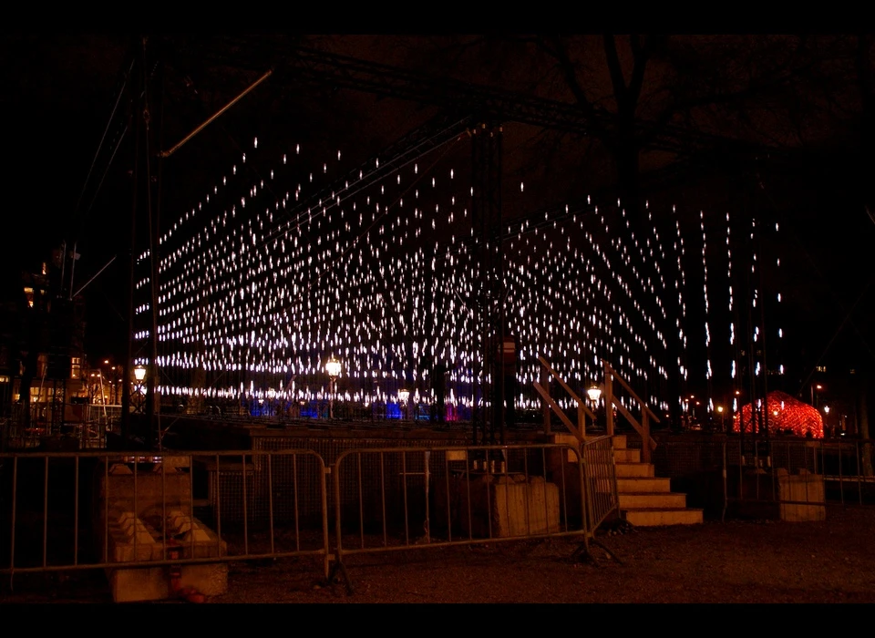 ‘Alley of Light’ is een driedimensionale matrix van bijna 2000 LED-lampen. De hangconstructie is vier meter hoog en twaalf meter 
					  lang. In het midden bevindt zich een lichtsteeg waar je doorheen kunt lopen. In plaats van bakstenen zie je nu duizenden lichtpuntjes, die voortdurend van sterkte veranderen. Open, dynamisch, betoverend – 
					  deze steeg vertegenwoordigt de beste kwaliteiten die Amsterdam te bieden heeft. (Serge Schoemaker (NL) is architect. Sinds 2008 runt hij zijn eigen kantoor. Hij is gastdocent aan verschillende universiteiten. 
					  Luuk van Laake (NL) studeerde Werktuigbouwkunde. Hij is gespecialiseerd in het ontwikkelen van technologie voor (licht)projecten en eigenaar van Digiluce.) 2014