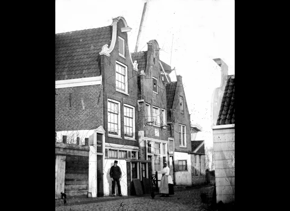 Gezicht op Bokkinghangen 9-13 (v.l.n.r.), boven de huizen wiek van molen De Bok op bolwerk Blauwhoofd (Jacob Olie, 1863)