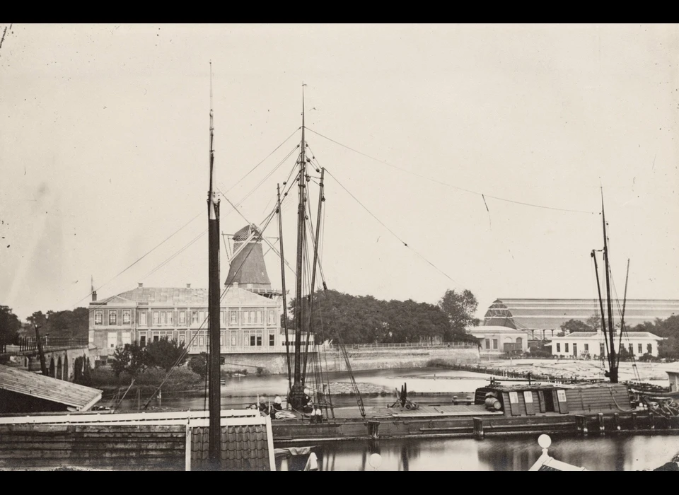 Bolwerk Oosterblokhuis met voor molen De Bul gebouw Apollo, rechts de nieuwe ijzeren overkapping van het Weesperpoortstation (Jan Adriaan van Eijk (1808-1887), 1862)